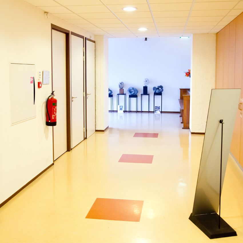 Gang met rode vloervlakken en beelden aan het einde