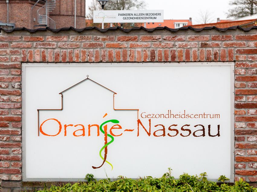 Bord met het logo van Gezondheidscentrum Oranje-Nassau op een bakstenen muur